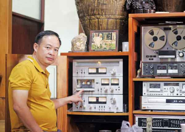 Anh Nguyễn Thành Chung bên các máy phát nhạc cổ xưa trong bộ sưu tập của mình. Ảnh: Phan Lài