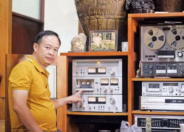 Anh Nguyễn Thành Chung bên các máy phát nhạc cổ xưa trong bộ sưu tập của mình. Ảnh: Phan Lài