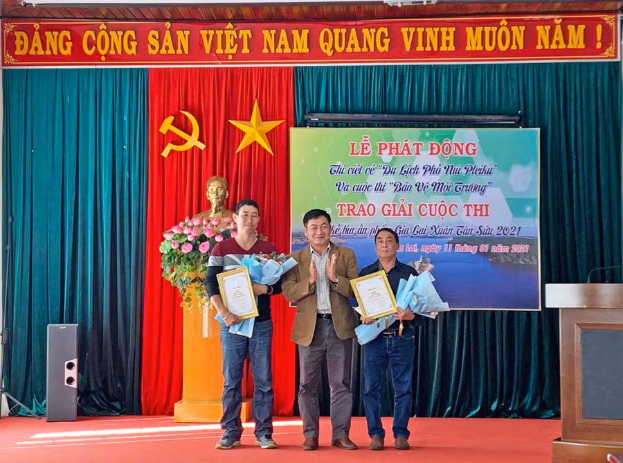 Nhà báo Huỳnh Kiên-Tổng Biên tập Báo Gia Lai (giữa) trao giải cho 2 tác giả đạt giải tại cuộc thi “Thiết kế bìa ấn phẩm Gia Lai Xuân Tân Sửu năm 2021”-ảnh Phương Linh