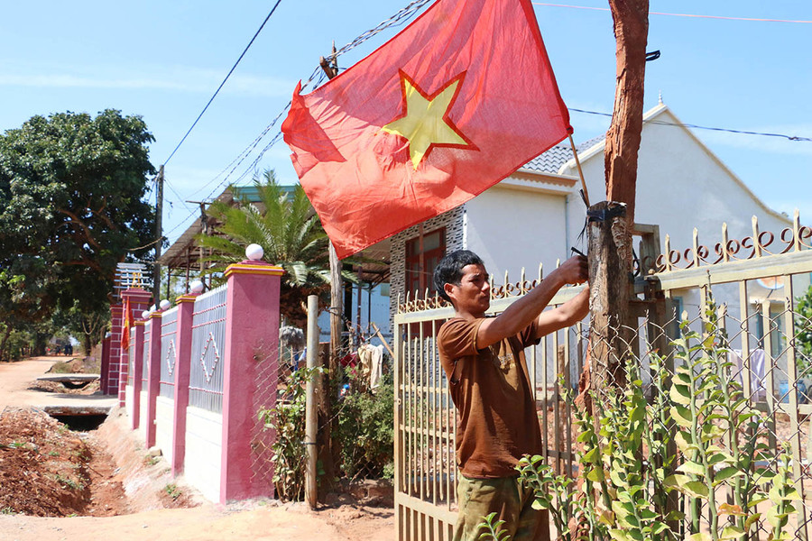  Anh Kpă Thái (làng Ia Pết, xã Ia Pal, huyện Chư Sê) treo cờ Tổ quốc hướng về Đại hội XIII của Đảng. Ảnh: Quang Tấn