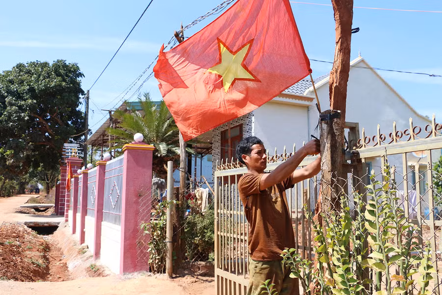  Anh Kpă Thái (làng Ia Pết, xã Ia Pal, huyện Chư Sê) treo cờ Tổ quốc hướng về Đại hội XIII của Đảng. Ảnh: Quang Tấn