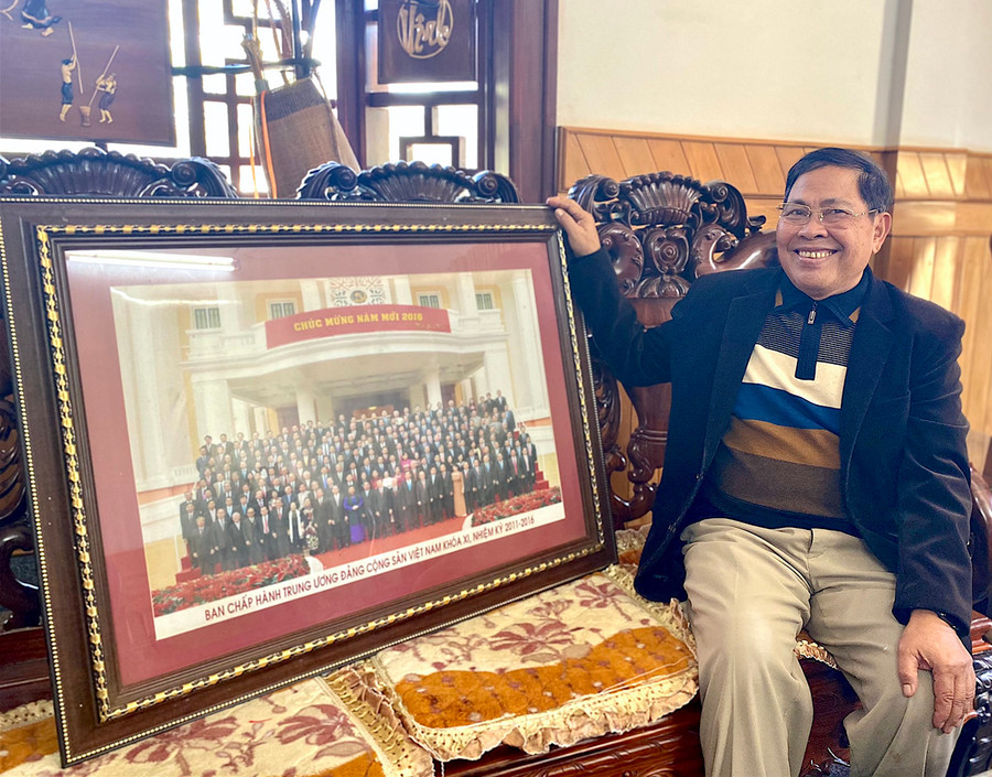 Nguyên Bí thư Tỉnh ủy Hà Sơn Nhin bên bức ảnh chụp lưu niệm với Ban Chấp hành Trung ương Đảng khóa XI. Ảnh: Hồng Thi