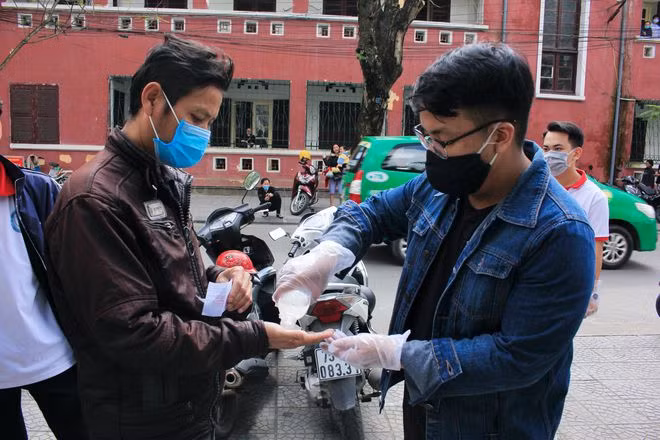 Bệnh nhân được sát khuẩn tay trước khi nhận cháo. Ảnh: NY LƯƠNG