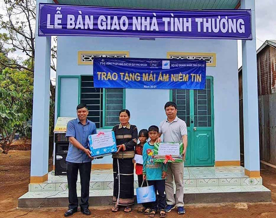 Ông Nguyễn Hữu Quế-Chủ tịch UBND TP. Pleiku (phải sang) trao tặng một số vật dụng thiết yếu cho gia đình bà Rơ Mah Kaih, làng Thong Ngó, xã Ia Kênh. Ảnh: Hà Phương