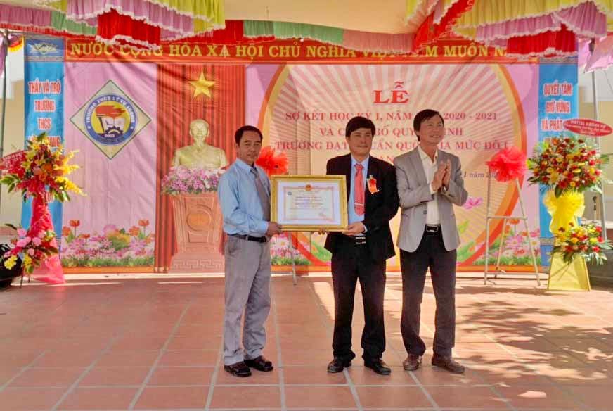 Ông Nguyễn Văn Vĩnh-Trưởng phòng Giáo dục và Đào tạo huyện Krông Pa (bìa phải) trao bằng công nhận trường đạt chuẩn quốc gia cho Trường THCS Lý Tự Trọng.Ảnh.Vũ Chi