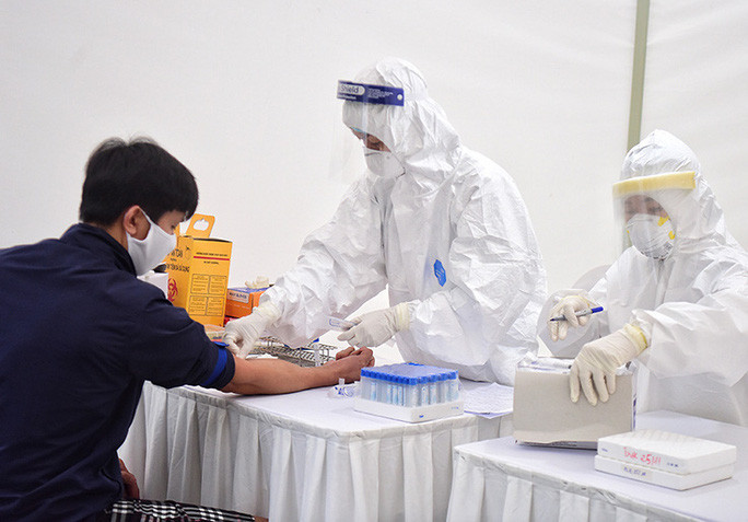 Nhân viên y tế lấy mẫu máu xét nghiệm Covid-19 cho bệnh nhân - Ảnh: Ngô Nhung