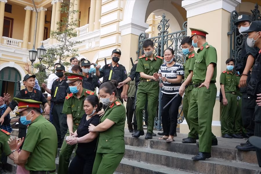  Các bị cáo áp giải ra xe. Ảnh:A.T