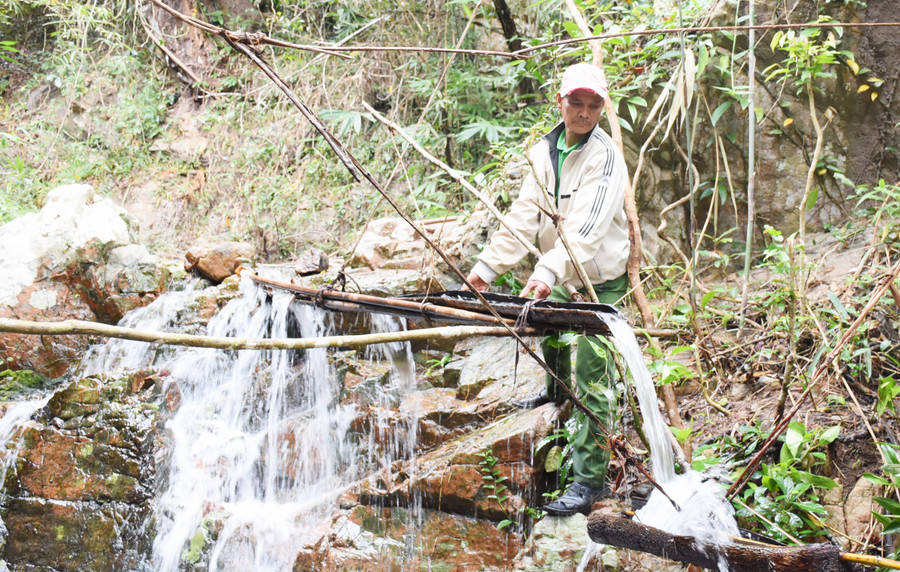 Ông Đinh Ngoai khơi thông dòng chảy để chỉnh âm cho dàn đàn nước. Ảnh: Phương Duyên