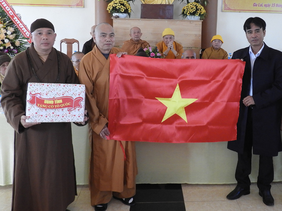 Phó Trưởng Ban Dân vận Tỉnh ủy ông Rơ Chăm La Ni trao tượng trưng cờ Tổ quốc cho Ban Trị sự Giáo hội Phật Giáo Việt Nam tỉnh. Ảnh: Thanh Nhật