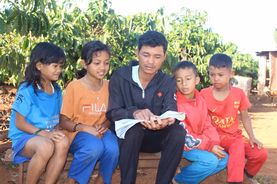 25-1 Anh A Ngam (ở giữa) luôn gần gũi, trò chuyện để các em học sinh gắn bó hơn với lớp học miễn phí. Ảnh P.L