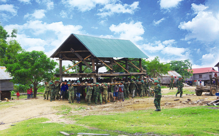 Cán bộ, chiến sĩ Sư đoàn 320 giúp người dân huyện Phú Thiện di dời nhà ở. Ảnh: Vĩnh Hoàng