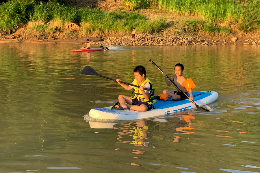 Các em nhỏ có dịp vui chơi giải trí và rèn luyện sức khỏe cực kỳ tốt khi tham gia chèo SUP. Ảnh: HT