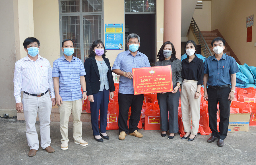  Ủy viên Ban Thường vụ Tỉnh ủy, Chủ tịch Ủy ban MTTQ Việt Nam tỉnh Hồ Văn Điềm (ở giữa) tặng túi an sinh cho hộ dân trong khu vực phong tỏa do ảnh hưởng bởi đại dịch tại phường Yên Đổ, TP. Pleiku. Ảnh: Anh Huy