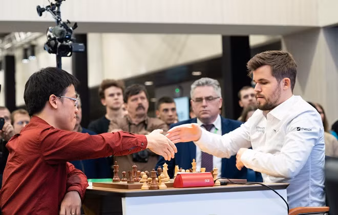  Lê Quang Liêm (trái) có chiến thắng lịch sử trước Carlsen. Ảnh: FIDE