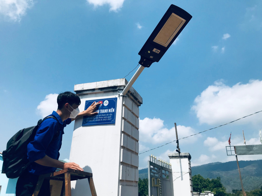 Thành viên nhóm Dự án Sách tình nguyện kiểm tra đèn năng lượng mặt trời sau khi lắp đặt cho làng Đak Mong (xã Đak Krong, huyện Đak Đoa). Ảnh: Phan Lài