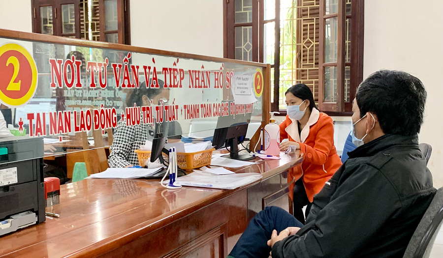  Cán bộ BHXH tỉnh hướng dẫn người dân các thủ tục liên quan chính sách BHXH. Ảnh: Như Nguyện
