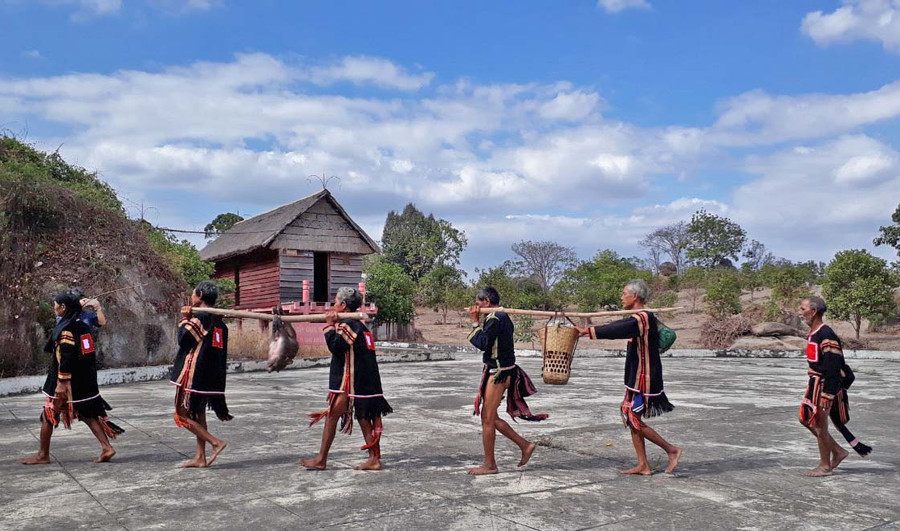 Phụ tá Vua Lửa đời thứ 14 Rơ Lan Hieo (bìa trái) cùng người làng mang lễ vật lên núi cúng cầu mưa. Ảnh: Vũ Chi