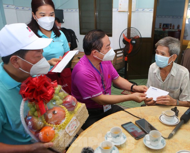 Nhà báo Lê Xuân Sơn cùng đại diện nhà tài trợ trao quà tri ân cựu tù Côn Đảo Nguyễn Xuân Viên.