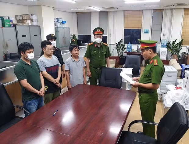 Lực lượng chức năng đọc lệnh bắt các bị can liên quan đến vụ án xảy ra tại Bệnh viện Đa khoa Đồng Nai, Công ty AIC và các đơn vị liên quan. Ảnh: Phạm Kiên - TTXVN