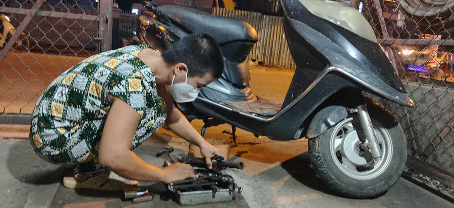 Chồng mất, chỉ còn mình chị Phương Tú sửa xe. Ảnh: Như Lịch