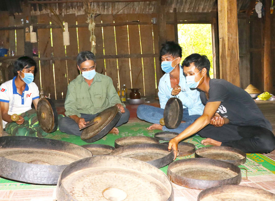 Ông Đinh Bơl (thứ 2 từ trái sang; làng Tăng Lăng, xã Krong, huyện Kbang) biết chỉnh chiêng và truyền dạy diễn tấu cồng chiêng cho thanh niên. Ảnh: Ngọc Minh