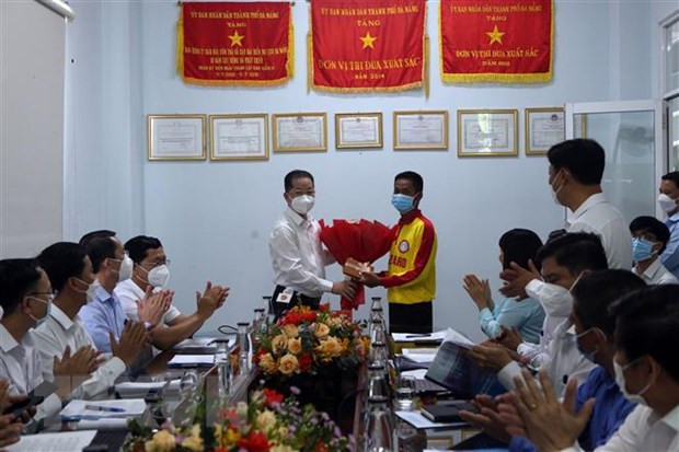 Bí thư Thành ủy Đà Nẵng Nguyễn Văn Quảng tặng quà cho ông Nguyễn Hữu Toàn Chung là nhân viên tổ cứu hộ số 10, đã ứng cứu kịp thời được 4 người gặp nạn khi đang tắm biển vào đêm ngày 27/3. Ảnh: Trần Lê Lâm/TTXVN