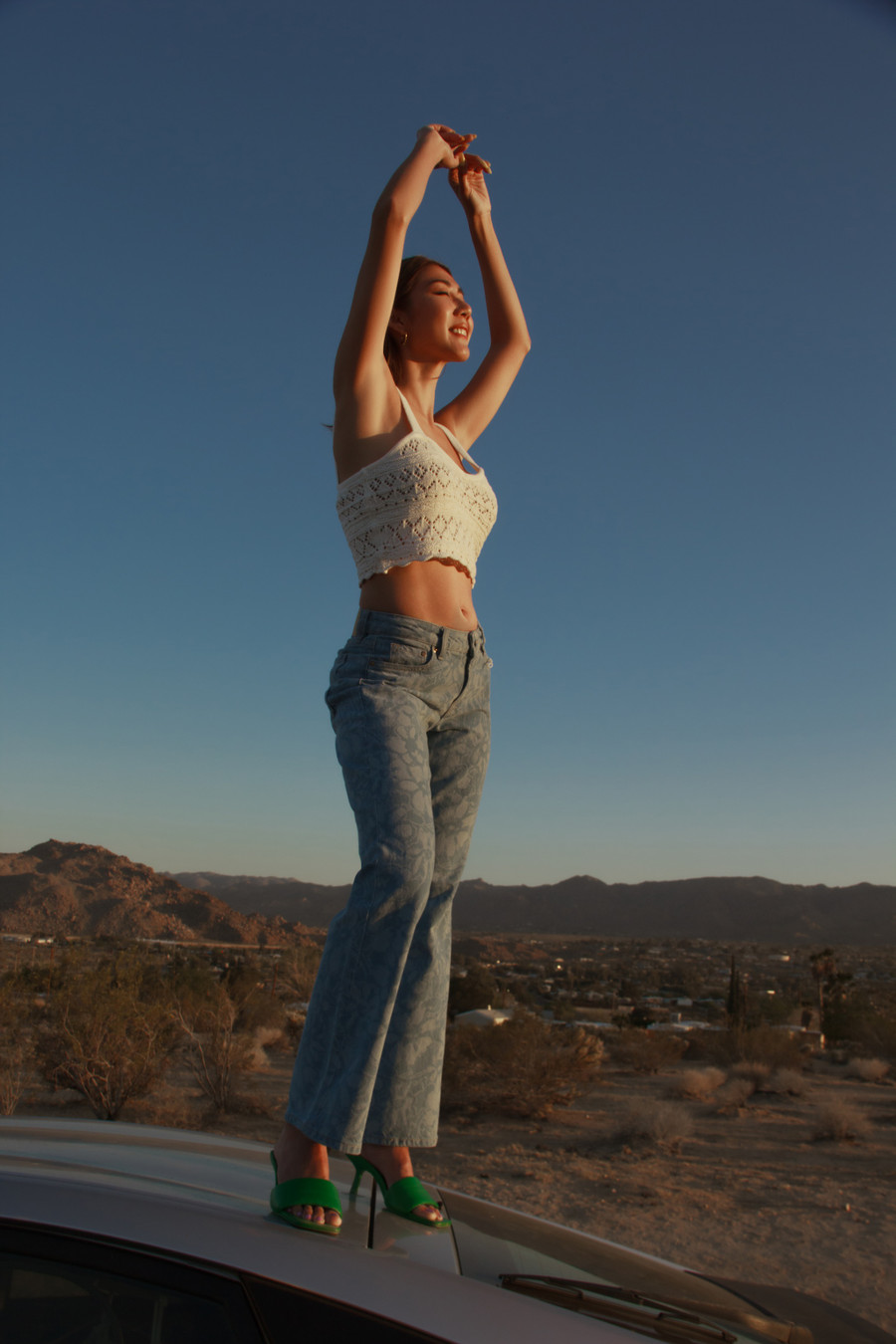 Mặc set đồ gồm quần jeans cạp cao và áo crop-top, Ngọc Quyên thấy mình trẻ trung và tràn đầy năng lượng. Cô đánh bạo đứng lên nóc chiếc xe hơi để chụp ảnh. Ảnh: Châu Phú