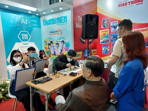 Độc giả trải nghiệm ký họa chân dung tại gian hàng Báo Thanh niên. (Ảnh: Minh Thu/Vietnam+) Độc giả trải nghiệm ký họa chân dung tại gian hàng Báo Thanh niên. (Ảnh: Minh Thu/Vietnam+)