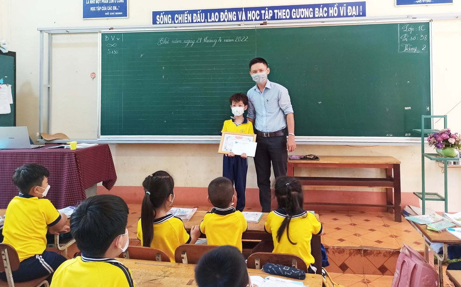 Anh Lê Đình Chiến-Bí thư Huyện Đoàn Đak Đoa tặng giấy khen gương người tốt-việc tốt cho em Đặng Bùi Phúc An. Ảnh: Kim Quân