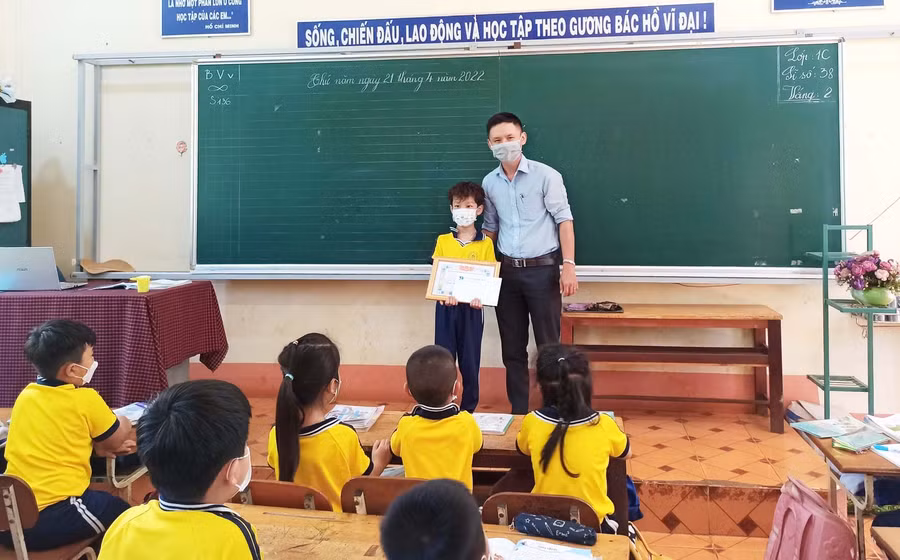 Anh Lê Đình Chiến-Bí thư Huyện Đoàn Đak Đoa tặng giấy khen gương người tốt-việc tốt cho em Đặng Bùi Phúc An. Ảnh: Kim Quân