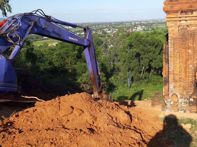 Đơn vị thi công đưa máy vào trong di tích tháp Bánh Ít để đào múc đất cạnh các tháp.