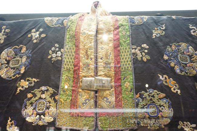 Theo các chuyên gia, với các họa tiết thêu loan, các chi tiết thêu trang trí tứ linh và màu áo có thể xác định đây là áo Nhật Bình dành cho các cung tần trong cung triều Nguyễn vào cuối thế kỷ 19. Theo các chuyên gia, với các họa tiết thêu loan, các chi tiết thêu trang trí tứ linh và màu áo có thể xác định đây là áo Nhật Bình dành cho các cung tần trong cung triều Nguyễn vào cuối thế kỷ 19.