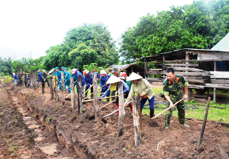 Cán bộ, chiến sĩ Trung đoàn Kinh tế-Quốc phòng 710 (Binh đoàn 15) giúp người dân xã Ia Lâu, huyện Chư Prông làm hàng rào. Ảnh: Vĩnh Hoàng
