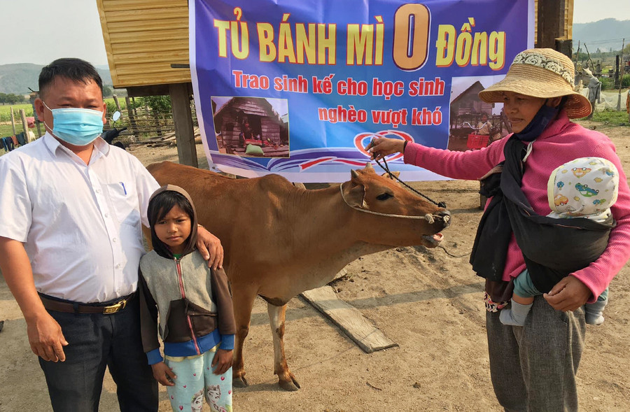  Thầy Vũ Văn Tùng trao bò sinh sản cho em Đinh Kdiết-học sinh lớp 3.2 Trường Tiểu học và THCS Đinh Núp (xã Pờ Tó, huyện Ia Pa). Ảnh: Vũ Chi