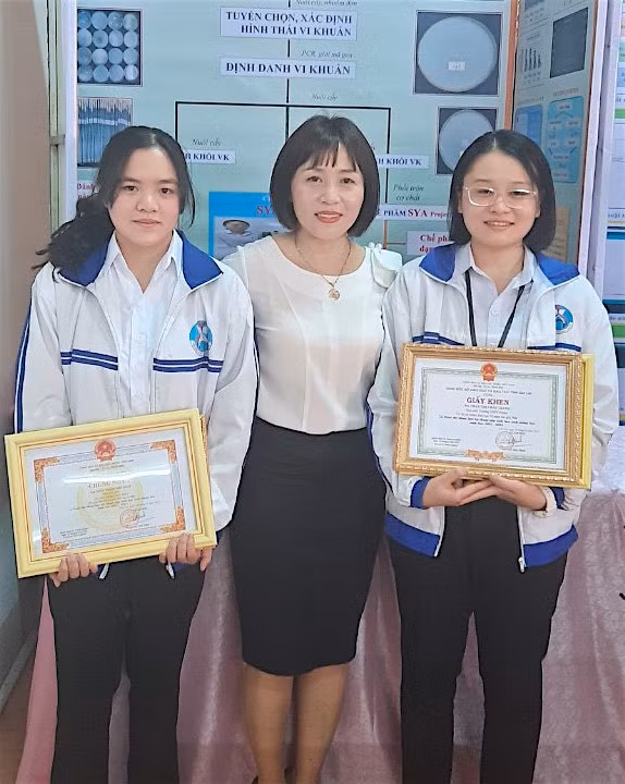Cô Lê Thị Thanh Xuân chung vui cùng 2 học trò khi dự án đạt giải nhì tại Cuộc thi Khoa học kỹ thuật cấp tỉnh học sinh trung học năm học 2021-2022. Ảnh: Hồng Thi