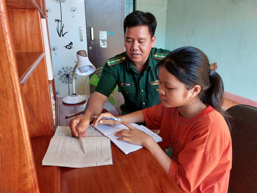 Trung úy Siu Thương hướng dẫn em Ksor Chơnh học bài. Ảnh: Thiên Thanh Trung úy Siu Thương hướng dẫn em Ksor Chơnh học bài. Ảnh: Thiên Thanh