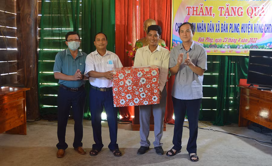  Trưởng ban Dân vận Tỉnh ủy Võ Thanh Hùng (bìa phải) tặng quà cho Đảng ủy-HĐND-UBND-Ủy ban MTTQ Việt Nam xã Đak Pling. Ảnh: An Nguyên