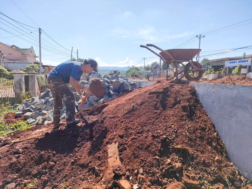 Anh Lê Anh Tú chở đất đá làm cầu tạm vào nhà vì mương nước của công trình quá cao. Ảnh: LK