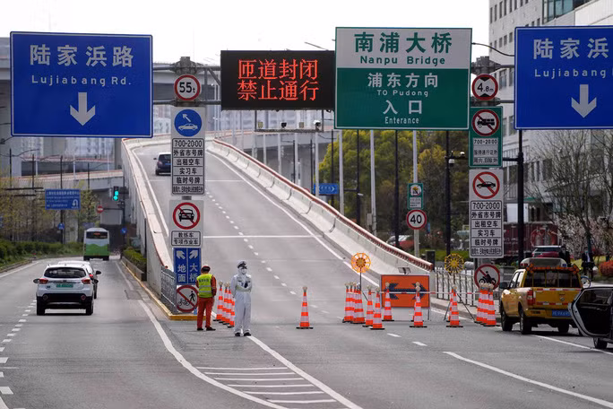 Cảnh sát mặc đồ bảo hộ đứng gác tại lối vào một đường hầm dẫn đến khu vực Phố Đông của TP Thượng Hải - Trung Quốc hôm 28-3 Ảnh: REUTERS