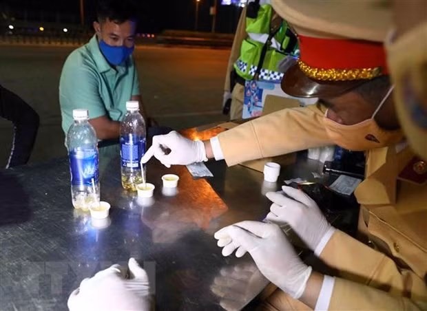 Kiểm tra nhanh ma túy với các tài xế lái xe đường dài. Ảnh: Phạm Kiên/TTXVN