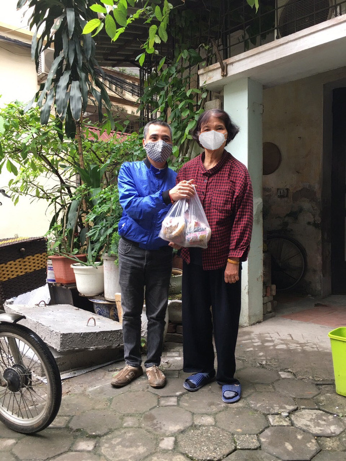 Ông Đỗ Đức Thanh (trái) đến tận nhà trao quà cho người khuyết tật bị ảnh hưởng bởi dịch Covid-19