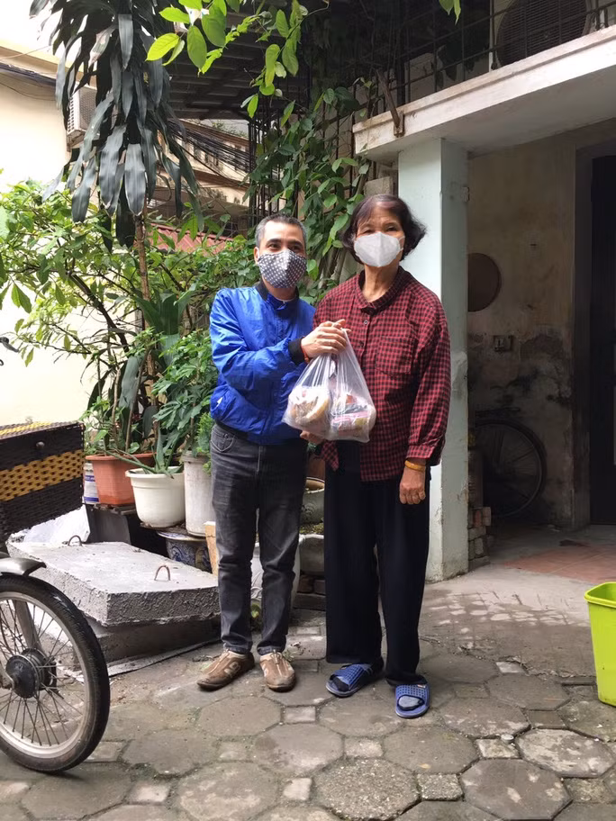 Ông Đỗ Đức Thanh (trái) đến tận nhà trao quà cho người khuyết tật bị ảnh hưởng bởi dịch Covid-19