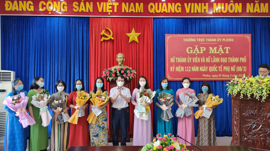 Đồng chí Trịnh Duy Thuân-Ủy viên BTV Tỉnh ủy, Bí thư Thành ủy, Chủ tịch HĐND TP. Pleiku tặng hoa và quà chúc mừng các nữ cán bộ lãnh đạo thành phố. Ảnh: Bá Bính