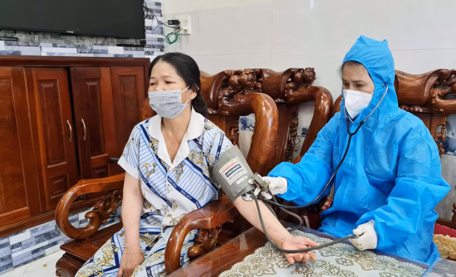 Nhân viên y tế kiểm tra huyết áp cho trường hợp F0 đang cách ly, điều trị tại nhà ở tổ 1 (phường Diên Hồng, TP. Pleiku). Ảnh: Bá Bính