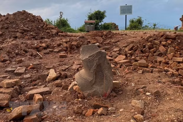 Một mảnh vỡ nghi là tượng Chăm cổ được phát hiện trong quá trình tháo dỡ tấm bêtông tại khu vực Tháp Chính. Ảnh: TTXVN phát