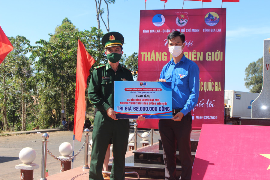 Đại diện Đoàn công tác Quận 12 (TP. Hồ Chí Minh) tặng bảng tượng trưng 25 đèn năng lượng mặt trời cho đại diện Bộ Chỉ huy Bộ đội Biên phòng tỉnh. Ảnh: Phan Lài