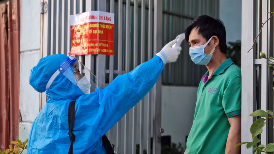 Nhân viên y tế kiểm tra thân nhiệt cho trường hợp F0 đang thực hiện cách ly, điều trị tại nhà ở tổ 4 (phường Chi Lăng, TP. Pleiku). Ảnh: Bá Bính