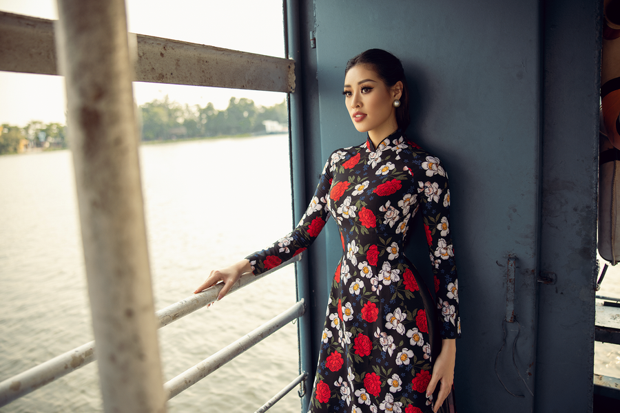 Ở bối cảnh đầu tiên tại bến phà, Hoa hậu Khánh Vân chọn áo dài màu đen hoạ tiết bông hoa, kết hợp kiểu tóc gợi nhớ đến hình ảnh những quý cô thành thị phồn hoa xưa. Giữa sông nước mênh mông – tượng trưng cho trăm ngàn lối rẽ cuộc đời, dòng nước vẫn chuyển động còn con người tưởng chừng đứng yên nhưng thật ra đang di chuyển theo dòng chảy của nước, Hoa hậu Khánh Vân thể hiện một khía cạnh khác của người phụ nữ: bình tĩnh trước mọi chuyện, suy nghĩ thấu đáo trước khi đưa ra một quyết định . Ở bối cảnh đầu tiên tại bến phà, Hoa hậu Khánh Vân chọn áo dài màu đen hoạ tiết bông hoa, kết hợp kiểu tóc gợi nhớ đến hình ảnh những quý cô thành thị phồn hoa xưa. Giữa sông nước mênh mông – tượng trưng cho trăm ngàn lối rẽ cuộc đời, dòng nước vẫn chuyển động còn con người tưởng chừng đứng yên nhưng thật ra đang di chuyển theo dòng chảy của nước, Hoa hậu Khánh Vân thể hiện một khía cạnh khác của người phụ nữ: bình tĩnh trước mọi chuyện, suy nghĩ thấu đáo trước khi đưa ra một quyết định .