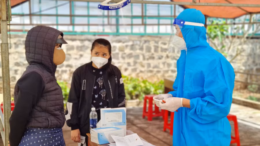 Nhân viên y tế phường Phù Đổng (TP. Pleiku ) hướng dẫn người dân cách ly, điều trị Covid-19 tại nhà. Ảnh: Bá Bính