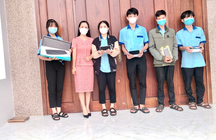 Cô Hoàng Thị Diệu Loan (thứ 2 từ trái qua) tặng máy tính và điện thoại thông minh cho các em học sinh Trường THPT Trần Quốc Tuấn (huyện Phú Thiện) học online trong mùa dịch. Ảnh: Phan Lài